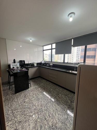 a kitchen with a counter and a table in it at Locking's Lourdes 3 in Belo Horizonte