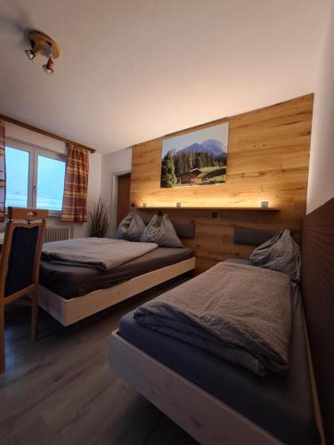 a bedroom with two beds and a painting on the wall at Haus Maria Wallinger in Abtenau