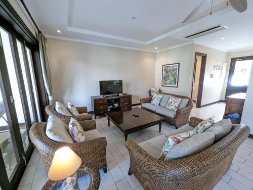 a living room with couches and a tv at Maison Bigorno by Simply-Seychelles in Eden Island