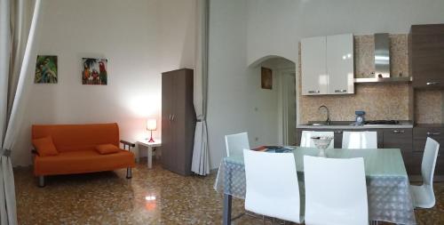 a kitchen and a dining room with a table and a chair at Casa Roberto in Campomarino