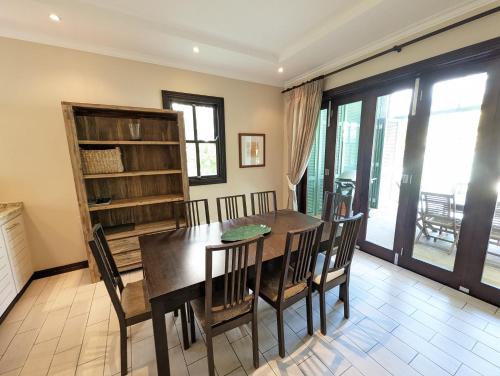 a dining room with a wooden table and chairs at Maison Bigorno by Simply-Seychelles in Eden Island