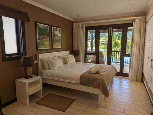 una camera con un grande letto e un balcone di Maison Bigorno by Simply-Seychelles a Eden Island