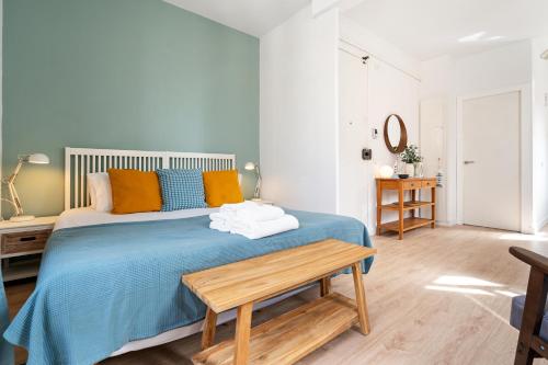 um quarto com uma cama azul e uma mesa de madeira em Lodging Apartments Barceloneta Beach Studio 42 em Barcelona
