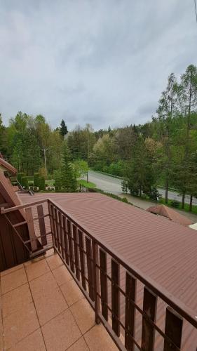 a wooden deck with a view of a tennis court at Zajazd-restauracja Zyga in Iwkowa