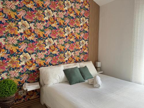 a bed in a room with a floral wall at Sea La Vie! in Novalja