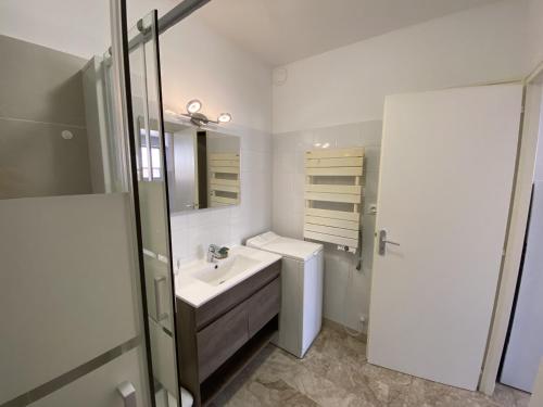 une salle de bain blanche avec un lavabo et des toilettes dans l'établissement Appartement 2 etoiles proche plage, à Les Sables-dʼOlonne