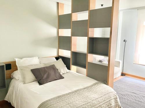 a bedroom with a large bed with a wall of shelves at Estudio Regenta Con Parking privado in Oviedo
