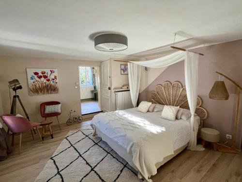 モンブリュン・レ・バンにあるLa Maison de Margueriteのベッドルーム(天蓋付きベッド1台付)