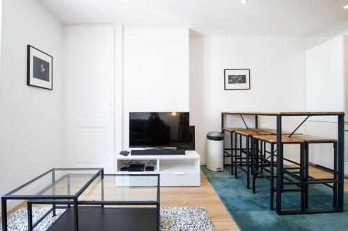 un salon avec une table en verre et une télévision dans l'établissement Lac Ness - Bel appartment central Part-Dieu, à Lyon