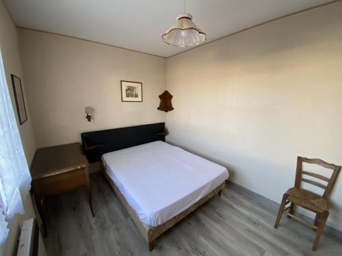 une petite chambre avec un lit et une chaise dans l'établissement Maison face mer La Chaume, à Les Sables-dʼOlonne