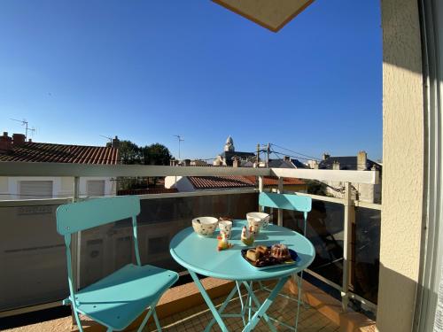 une table bleue et des chaises sur un balcon dans l'établissement Appartement - PARKING - BALCON - Arago, à Les Sables-dʼOlonne