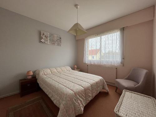 une chambre avec un lit, une chaise et une fenêtre dans l'établissement Appartement - PARKING - BALCON - Arago, à Les Sables-dʼOlonne