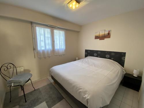une chambre avec un lit et une chaise dedans dans l'établissement Appartement proche plage - BALCON, à Les Sables-dʼOlonne
