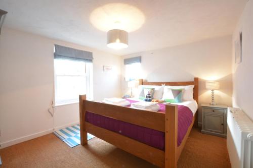 a bedroom with a bed with a wooden bed frame at 1 South Cottages in Thorpeness