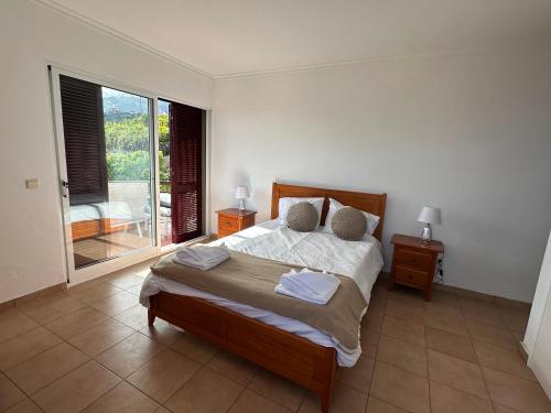 um quarto com uma cama grande e uma varanda em São Sebastião l- 5 min from Airport em Santa Cruz - Madeira