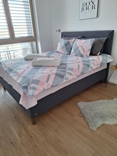 ein Bett mit einer karierten Bettdecke und Kissen im Schlafzimmer in der Unterkunft Aleksandar in Subotica