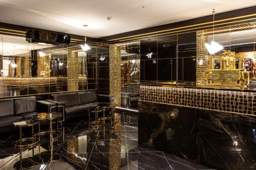 eine Bar mit schwarz und gold gefliesten Wänden in der Unterkunft Hotel Iskierka Business & Spa in Mielec