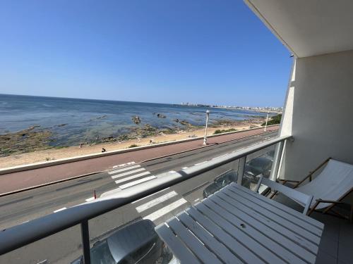 - un balcon avec un banc et la plage dans l'établissement Studio face mer - PARKING - Les Presidents, à Les Sables-dʼOlonne
