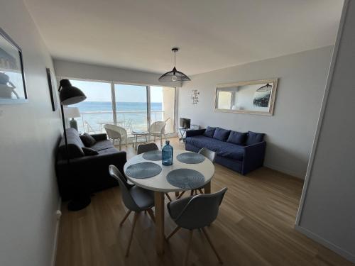 un salon avec une table et des chaises dans l'établissement Studio face mer - PARKING - Les Presidents, à Les Sables-dʼOlonne