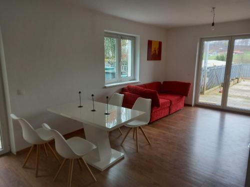 uma sala de estar com uma mesa e um sofá vermelho em Markus Doppler em Salzburgo