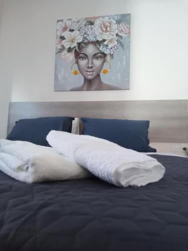 Una cama con una almohada blanca y una foto de una mujer en EvropisHouse en Kozani