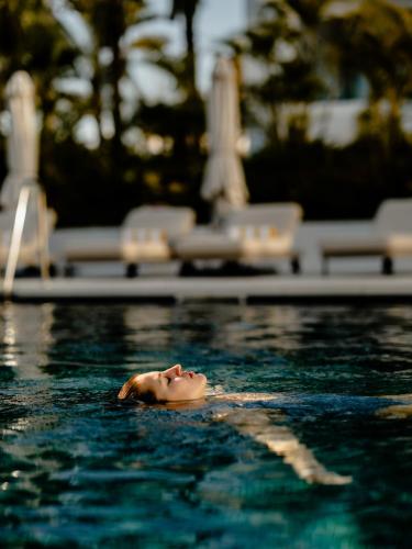 a woman swimming in a pool in the water at THE FLAG HOTEL Marbella, Estepona Adult Recommended in Estepona