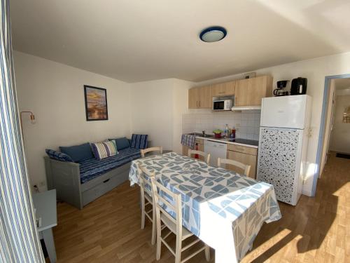 une petite cuisine avec une table et un réfrigérateur dans l'établissement Appartement avec piscine - La Chaume, à Les Sables-dʼOlonne