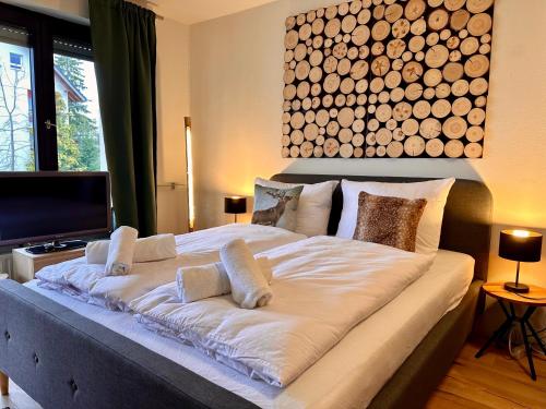 Un dormitorio con una gran cama blanca con una gran pared de troncos en Gemütliche Ferienwohnungen mit Pool & Sauna, en Höchenschwand