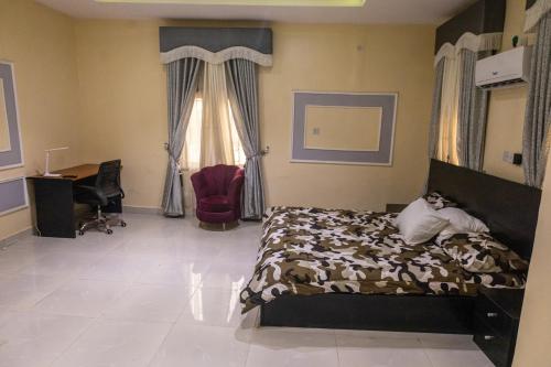 1 dormitorio con cama, escritorio y ventana en VETTAS APARTMENT, en Akure