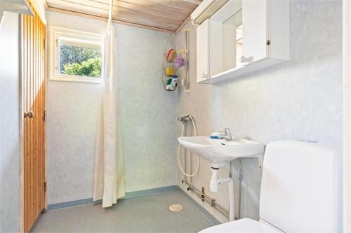 ein Bad mit einem Waschbecken, einem WC und einem Fenster in der Unterkunft Spacious villa with beautiful location outside Lottorp in Löttorp