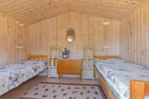 2 Betten in einem Zimmer mit Holzwänden in der Unterkunft Spacious villa with beautiful location outside Lottorp in Löttorp