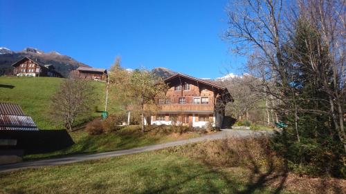 ein Haus auf einem Hügel mit Bergen im Hintergrund in der Unterkunft Chalet Pfyffer - Mountain view in Grindelwald