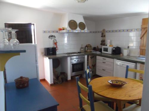 a kitchen with a wooden table and a table and a dining room at Courela do Salgueiro in Carocha
