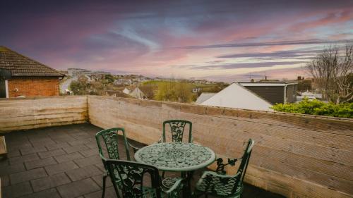 a patio with a table and chairs on a balcony at Freshly Renovated Apartment on High Street in Saltdean