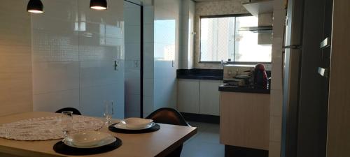 a kitchen with a table with two plates on it at Quarto Bem no Centro Dourados in Dourados