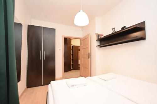 una stanza con due tavoli bianchi e un armadio nero di Victus Apartamenty, Apartament Chill a Sopot