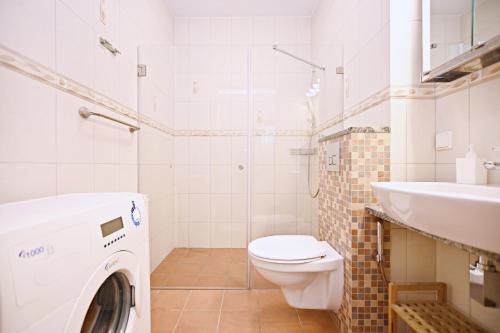 bagno con servizi igienici, lavandino e lavatrice di Victus Apartamenty, Apartament Chill a Sopot