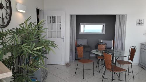 une salle à manger avec une table et des chaises en verre dans l'établissement Appartement 2 étoiles face mer - 50m de la plage, à Les Sables-dʼOlonne