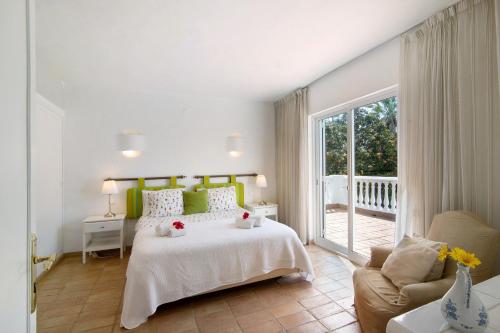 - une chambre blanche avec un lit et un canapé dans l'établissement Quinta da Balaia V3, à Albufeira