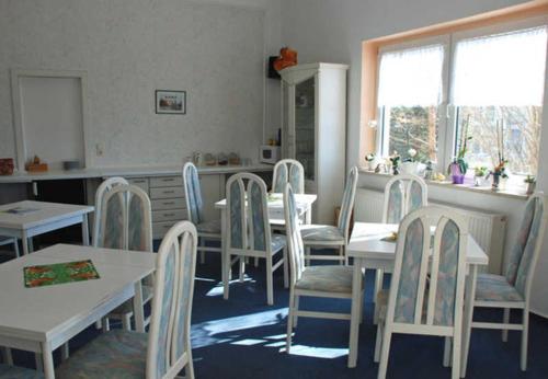 a dining room with white tables and chairs at Villa im Ostseebad Baabe in Baabe