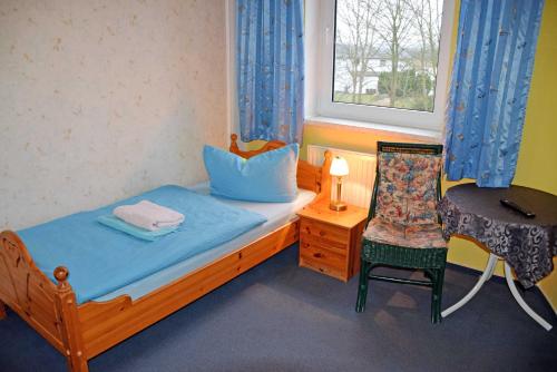 a bedroom with a bed and a chair and a window at Villa im Ostseebad Baabe in Baabe