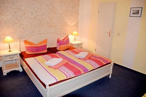 a bedroom with a bed with two tables and two lamps at Villa im Ostseebad Baabe in Baabe