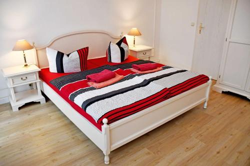 a bedroom with a large bed with red and black pillows at Villa im Ostseebad Baabe in Baabe
