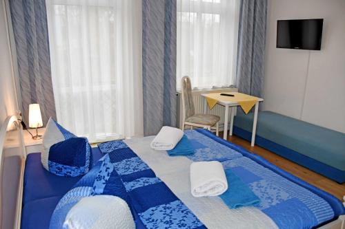 a blue and white bed in a room with a table at Villa im Ostseebad Baabe in Baabe