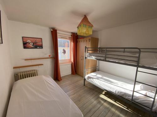 1 Schlafzimmer mit 2 Etagenbetten und einem Fenster in der Unterkunft Maison de ville 2 etoile proche plage in Les Sables-dʼOlonne