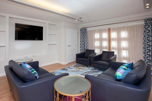 a living room with two blue couches and a tv at ※ Spacious Georgian Coach House & with Parking (TCH) ※ in Bath