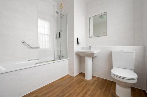 a bathroom with a toilet and a sink and a shower at Royal Whitby in Whitby