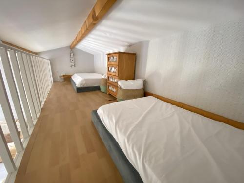 une petite chambre avec deux lits et une fenêtre dans l'établissement Maison 1 etoile proche gare et commerces, à Les Sables-dʼOlonne