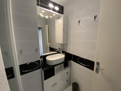 une salle de bain avec un lavabo et un miroir dans l'établissement Maison 1 etoile proche gare et commerces, à Les Sables-dʼOlonne