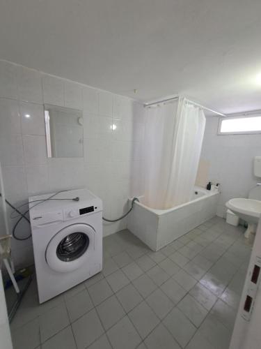 een witte badkamer met een wasmachine en een bad bij Fellini talpiot roof dolce vita in Haifa